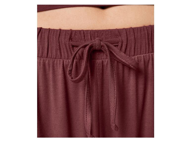 Gros plan sur la taille d'un pantalon de jogging bordeaux avec cordon.