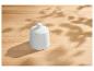 Sucrier blanc sur une table en bois avec des ombres de feuilles.