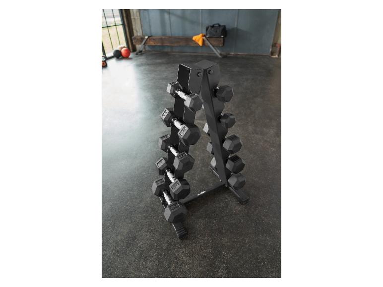 Un support noir pour haltères avec des haltères de différents poids dans une salle de sport.