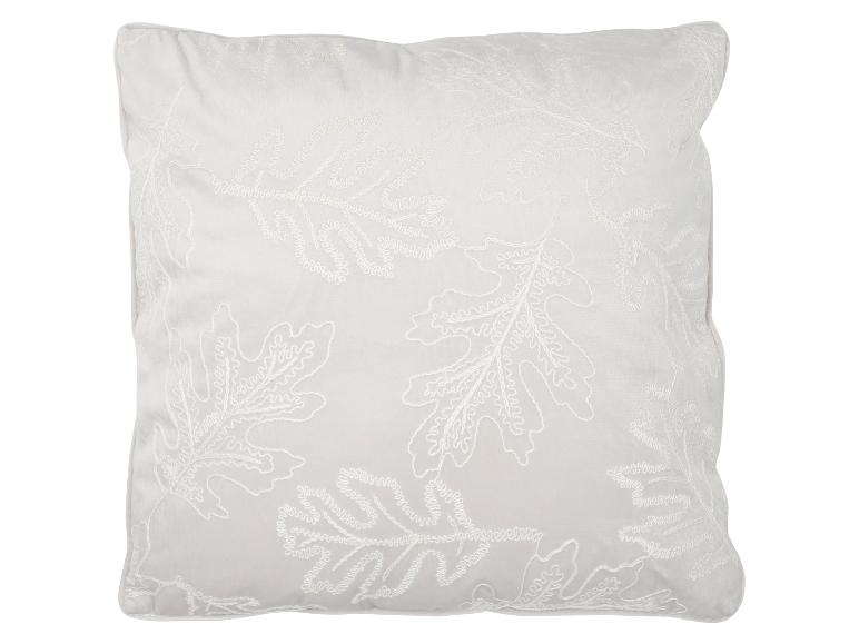 Coussin décoratif blanc avec des motifs de feuilles blanches.