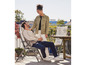 Deux personnes assises sur un balcon sur une chaise avec un coussin tropical.