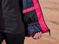 Gros plan sur une veste rose et noire avec une fermeture éclair.