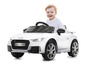 Un enfant conduit une voiture jouet Audi TT RS blanche.