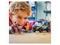 Un garçon joue avec un camion de police jouet, une moto et des figurines sur une table en bois.