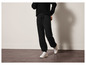 Pantalon de survêtement noir avec doublure en polaire et baskets blanches.