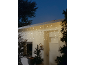Guirlande lumineuse stalactite sur une cabane en bois blanc décorée pour Noël