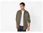 Homme en surchemise vert olive, t-shirt blanc et jean foncé.