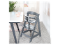 Chaise haute en bois Stokke Tripp Trapp grise dans une chambre d'enfant.