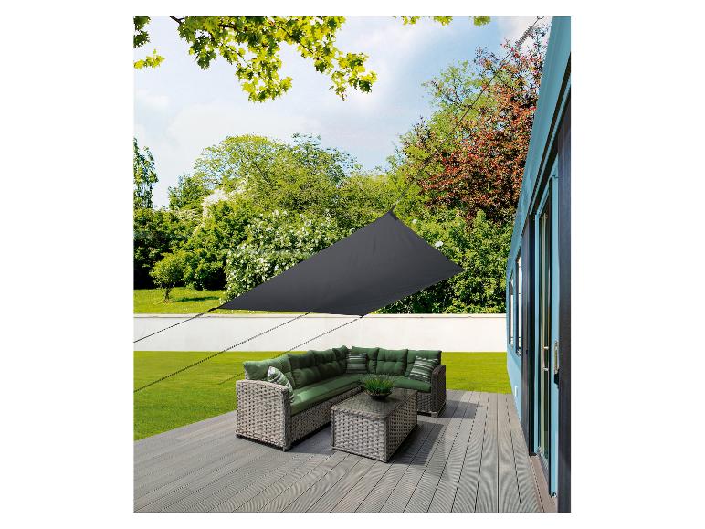 Parasol d'extérieur, salon de jardin en rotin et coussins verts.