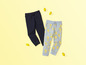 Deux pantalons de survêtement, un bleu foncé et un bleu clair avec des citrons.