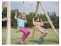 Deux enfants jouent sur une balançoire en bois en extérieur.