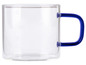 Une tasse en verre avec une poignée bleue.