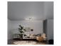 Un canapé d'angle blanc dans un salon moderne avec un luminaire de plafond design.