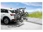 Deux VTT sur un porte-vélos à l'arrière d'un SUV blanc.