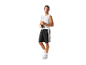 Homme en débardeur blanc et short de basket noir, tenant une bouteille d'eau.