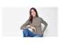 Modèle portant un pull col roulé gris et un jean.