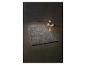 Tapis gris moelleux et lampe de table sur des livres sur fond sombre.