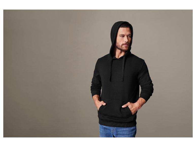 Un homme portant un sweat-shirt à capuche noir.