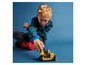 Un enfant joue avec un bulldozer LEGO jaune.