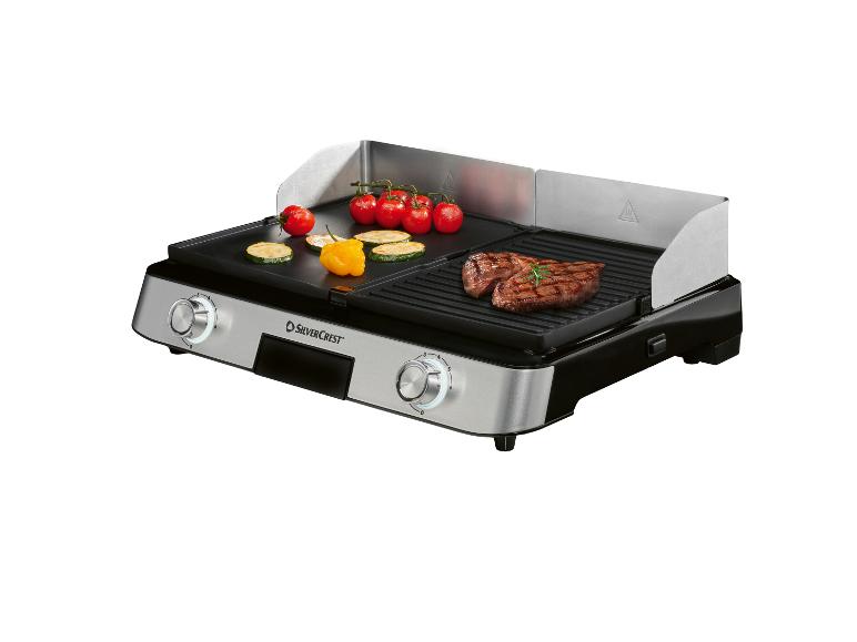 Grill électrique avec surface plate et rainurée, avec steak, tomates et courgettes.
