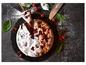 Une tarte aux cerises saupoudrée de sucre glace, servie sur une ardoise noire.