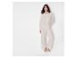 Femme vêtue d'une chemise blanche à rayures et d'un pantalon assorti.