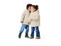 Deux enfants en doudounes crème et jeans, l'un chuchotant à l'autre.