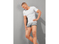 Homme en t-shirt blanc et boxer gris.
