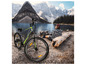 Un vélo électrique gris avec des détails verts et des pneus Kenda dans un paysage montagneux.