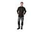 Homme en veste softshell noire et pantalon de travail gris.