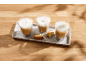 Trois boissons au café avec de la mousse et deux biscuits sur un plateau.