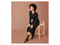 Une femme portant une robe noire et des bottes brunes.