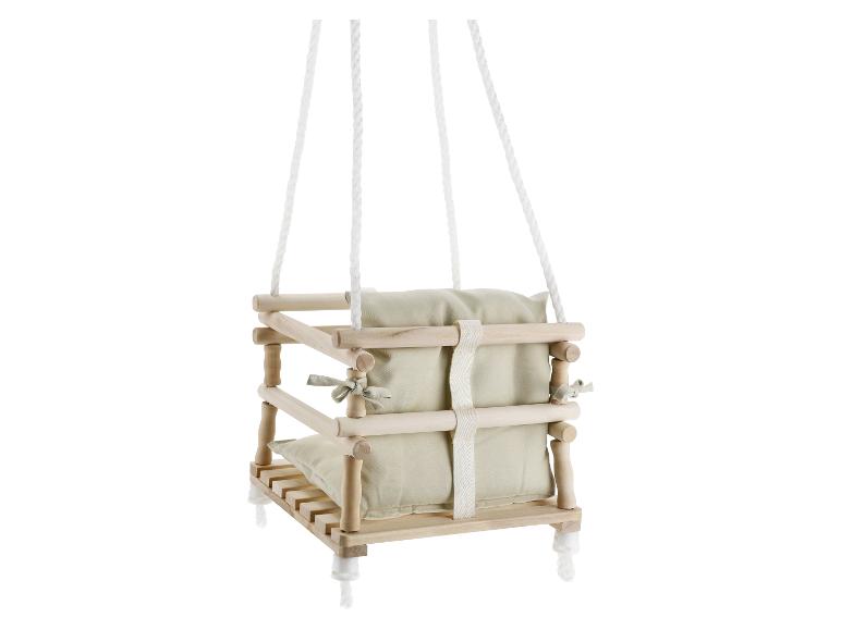 Balançoire bébé en bois avec coussins beiges, suspendue par des cordes blanches.