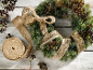 Couronne de Noël avec ruban de jute et baies sur fond de bois blanc.