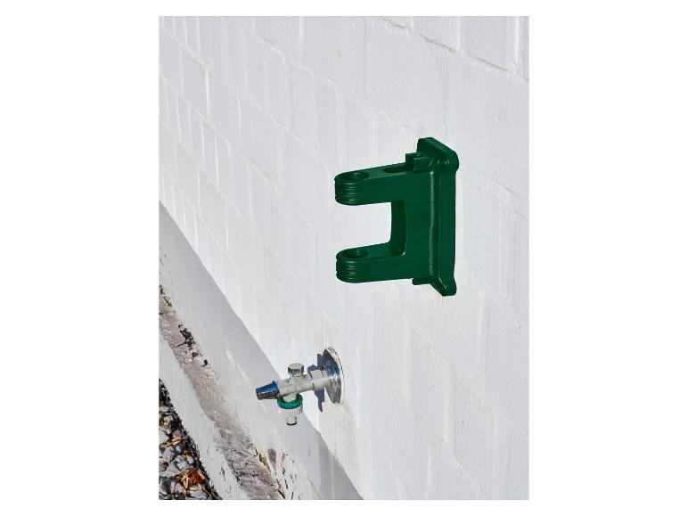Support mural vert pour tuyau d'arrosage avec un robinet en dessous.
