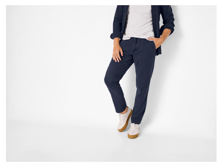 Homme en pantalon bleu marine, t-shirt blanc et chemise bleu marine.