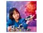 Une enfant joue avec des jouets LEGO : un vaisseau spatial et une base spatiale.