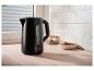 Bouilloire SilverCrest noire avec des biscuits et un pot en verre dans une cuisine.
