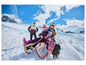 Deux enfants sur une luge en bois dans la neige.