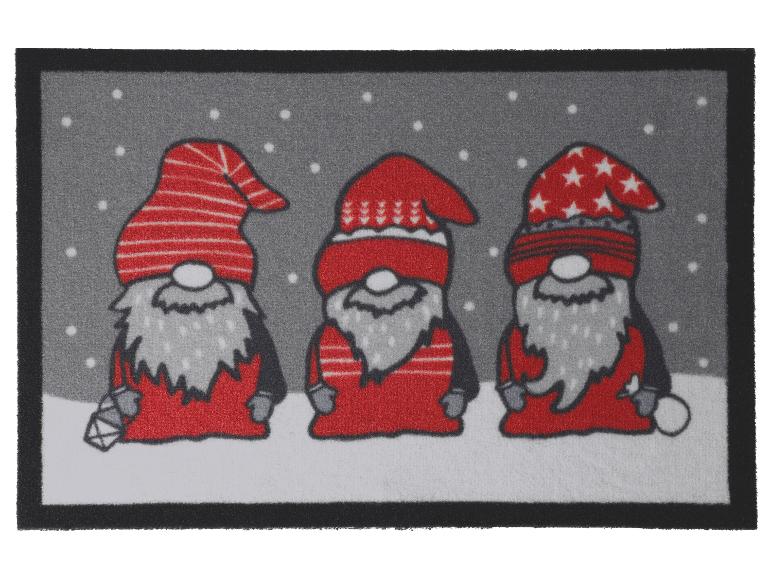 Un paillasson de Noël avec trois gnomes en chapeaux et tenues rouges sur un fond enneigé.