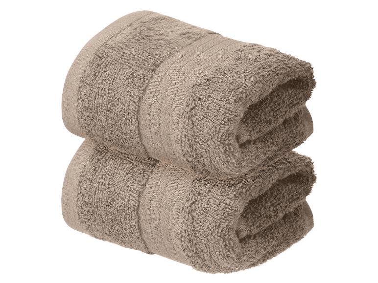 Deux serviettes marron pliées sur fond blanc