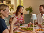 Trois personnes dînent avec une lampe Philips Hue sur la table.