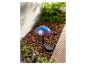 Lampe solaire en forme de champignon dans un jardin.