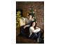 Un couple en pyjama de Noël assis sur un canapé devant un sapin de Noël.