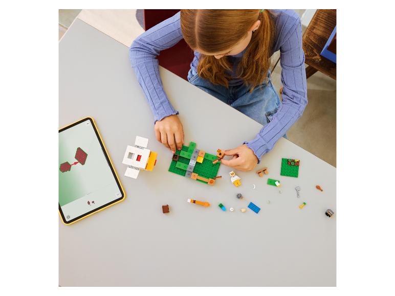 Fille construisant un jouet en briques, avec des instructions sur une tablette.