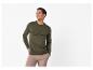 Homme souriant portant un t-shirt Henley vert olive et un pantalon en velours côtelé beige.