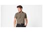 Homme en polo tricoté marron et pantalon noir, posant la main dans la poche.