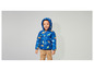 Un petit garçon porte une veste bleue à imprimé dinosaures