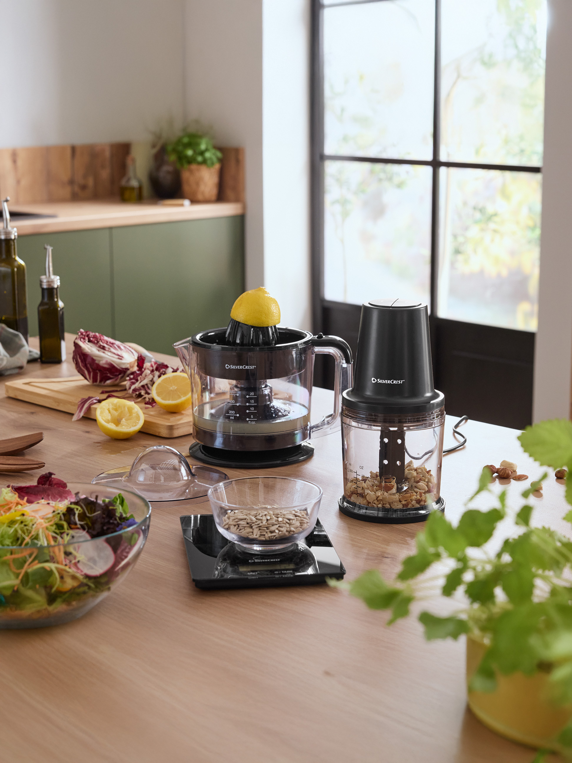 Comptoir de cuisine avec presse-agrumes SilverCrest, hachoir et un bol de salade.
