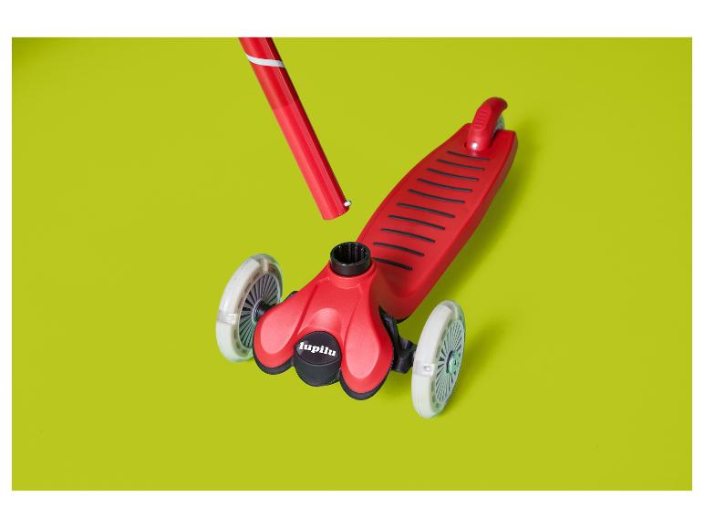 Trottinette rouge pour enfants Lupilu à trois roues sur fond vert lime.